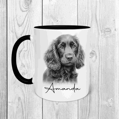 A white mug with a black handle and a black inside.  Image printed on the front of the mug is a sketch of a cocker spaniel with the name Amanda written underneath in black text.