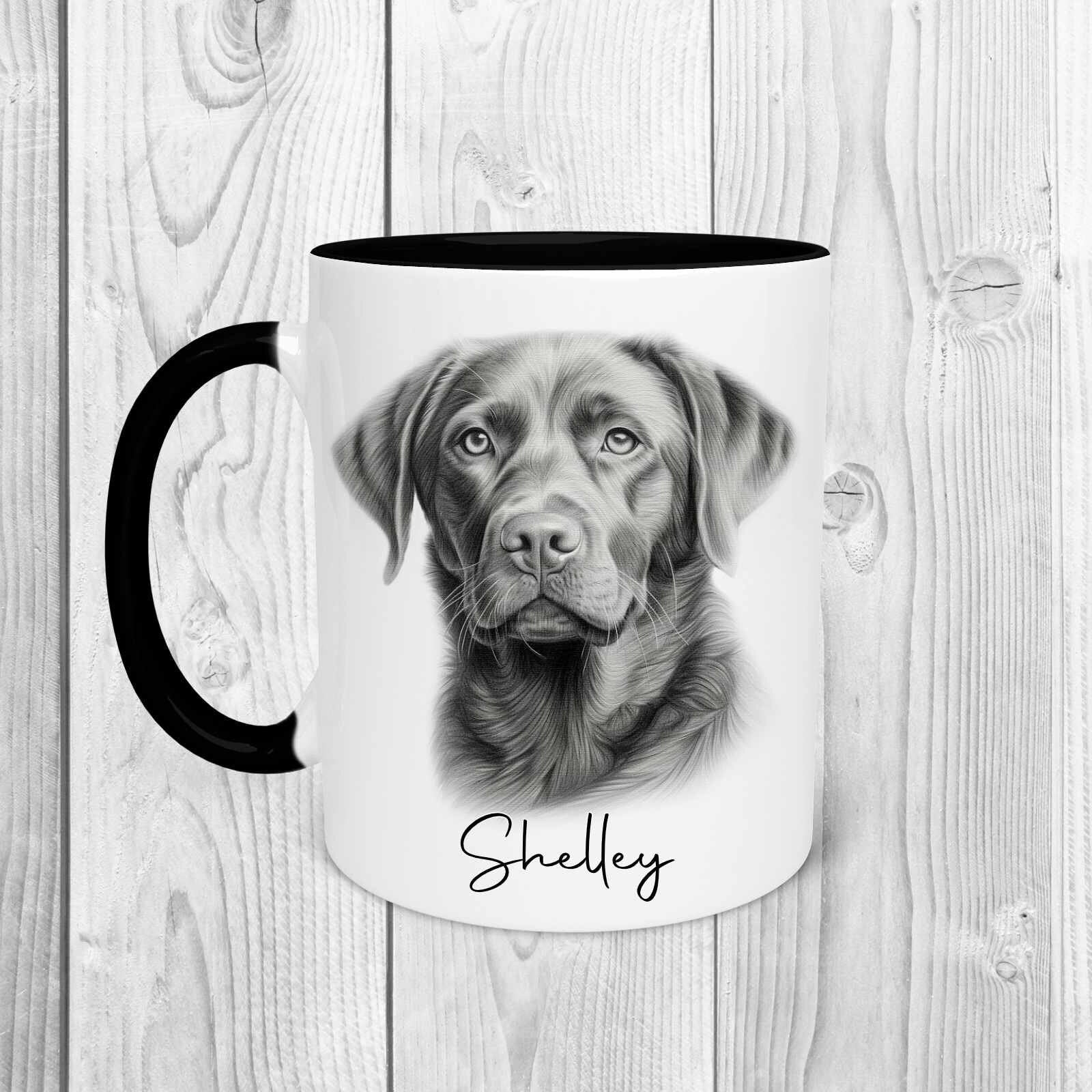 A white mug with a black inside and a black handle featuring a dark labrador dog in a sketchy style, with a name underneath in cursive text