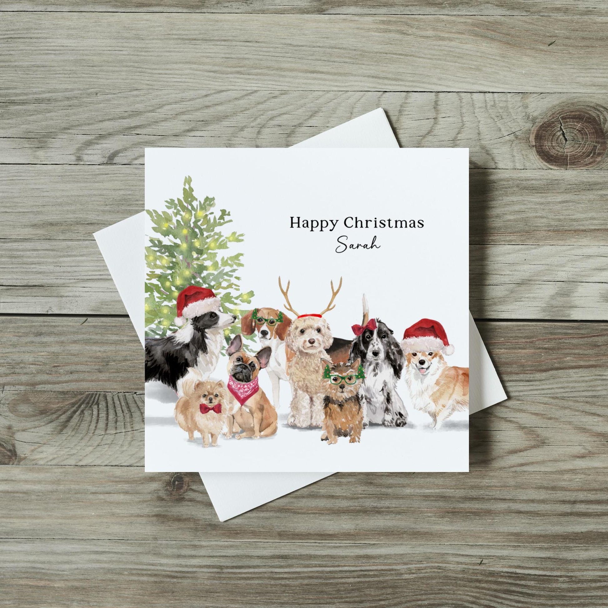 A square, white card with 8 dogs on and a sign saying&quot;party this way&quot;.  Text reading Happy Christmas Sarah is written under the image.  Dog breeds include a cockerpoo, a border collie, a beagle, a cocker spaniel.